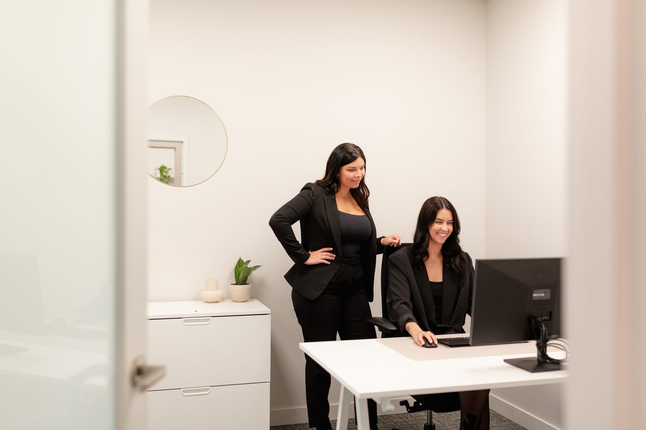 Deux femmes regardant un écran d'ordinateur dans un bureau