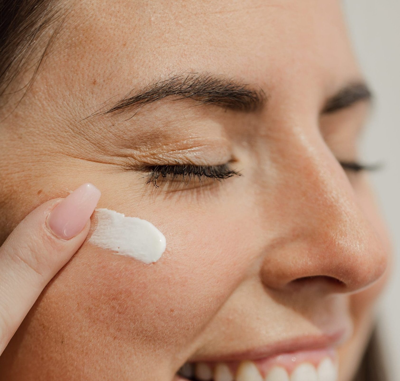 Femme appliquant de la crème dans son visage